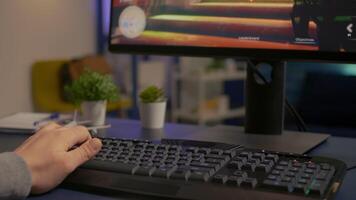 Close-up of player using RGB keyboard during online space shooter tournament. Pro gamer playing digital games on powerful computer late at night in gaming home studio video