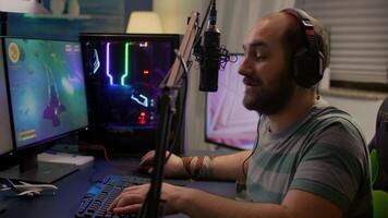 Winner streamer playing online space shooter game in gaming room using RGB keyboard and system desktop. Cyber performing on powerful pc talking with players on chat open during live competition video