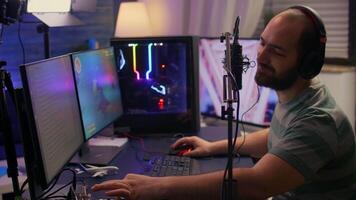 Streamer cyber performing space shooter game on powerful pc talking with players on chat open during professional competition. Player man using professional headphones in streaming home studio video