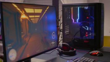 Close-up of professional monitor with first person shooter game on. Home studio of esport game player using powerful gaming computer during online competition video