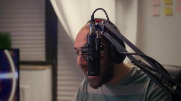 Close-up of streamer man talking into microphone with other players during space shooter tournament. Online streaming cyber performing games competition using technology network wireless video
