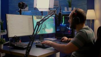 Streamer man winning space shooter online competition using professional microphone, keypad, mouse in gaming home studio. Player playing online games with streaming chat open during tournament video