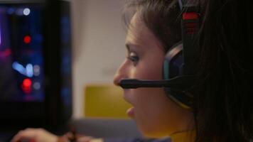 Close-up portrait of pro gamer playing online space shooter for digital competition. Player talking into microphone with multiple players using headset during gaming tournament video