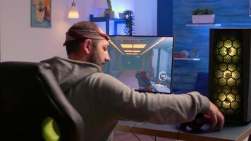 Addicted gamer performing cyber games using professional headphones in gaming room. Competitive gamer playing game tournament with new graphics on powerful computer. video