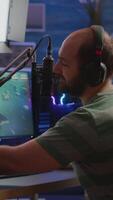verticale . homme banderole cyber vérification du son à mixer performant espace tireur Jeu sur rgb puissant ordinateur parlant avec joueurs sur courant bavarder et microphone dans jeu concours. joueur homme diffusion video