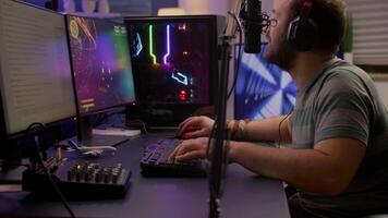 Game over for streamer playing space shooter games using professional RGB keyboard and mouse. Pro gamer talking into microphone on streaming chat during online tournament video