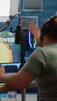 Vertical . Videogame streamer losing online videogame competition wearing professional headset talking on stream chat. Sad gamer using powerful computer for gaming tournament late night playing space shooter game video