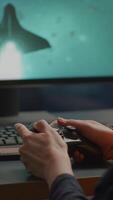 Vertical . Closeup of competitive woman player holding joystick playing space shooter games at powerful computer late night. Professional gamer using wireless controller for online gaming championship video