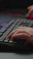 Vertical . Close-up on hands of pro cyber man playing game using RGB keyboard. Virtual championship in cyberspace, esports player performing on powerful computer during online esports gaming tournament video
