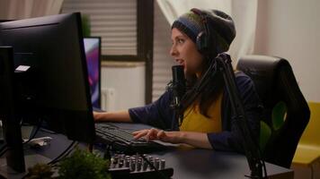 Pro streamer playing online games using RGB keypad, sound mixer, professional headphones. Cyber performing on powerful pc talking with players on chat open during professional competition video