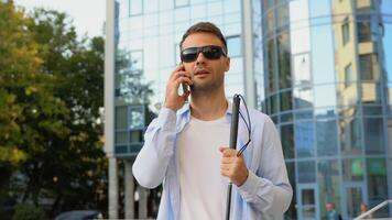 Handsome blinded man with walking stick talking on the phone video
