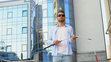 Blind man setting up walking cane on the street near the business center video