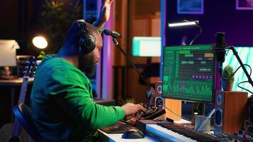 Sound engineer mixing and mastering new music on console and daw software in home studio, twisting pre amp knobs. Talented composer producing songs for the industry. Camera A. video