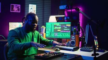Music producer explaining faders and knobs on mixing console before teaching advanced post production stuff. Musical instructor gives advice about acoustical engineering, online vlog. Camera B. video