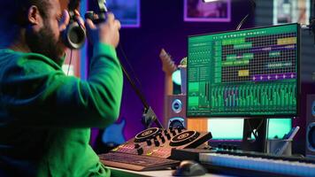 Skilled audio technician editing recorded tracks from an usb stick, using raw files to apply mix and master techniques. Artist producing music, adjusting volume levels on digital software. Camera A. video