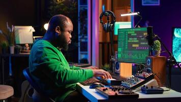 Artist playing electronic piano keyboard notes and recording audio files to use mix and master techniques, editing recordings to edit sound effects. Musician operating on synthesizer gear. Camera A. video