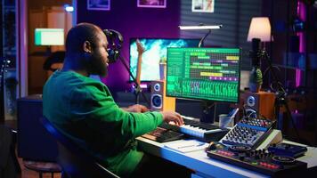Talented artist composing new lyrics for his tracks and recording music with audio devices in his home studio. Singer composer writes melodic material by taking notes and creating rhymes or songs. Camera B. video