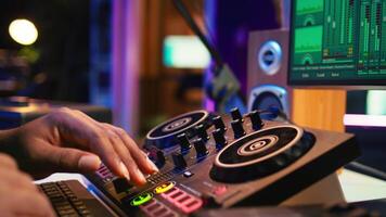 Audio engineer with headset mixing and mastering his recorded files, operating on a professional soundboard in home studio. Artist producer composing new tracks with sound effects. Camera B. video
