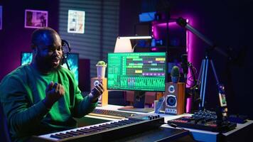 Musician doing online paid classes to help people play piano notes, teaching lessons from his home studio and recording tutorials. Musical instructor playing midi controller keyboard. Camera B. video