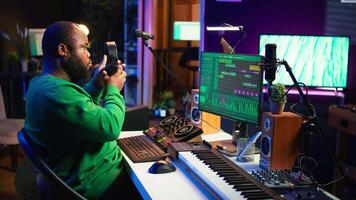 Talented musician mixing and mastering songs on a console, twisting pre amp knobs to add sound effects in post production. Producer composing tracks for album, working in home studio. Camera B. video