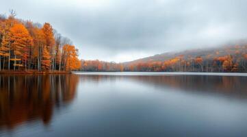 Autumn Reflections Over Calm Lake With Colorful Trees In Misty Mountains photo