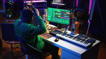 Skilled audio technician editing recorded tracks from an usb stick, using raw files to apply mix and master techniques. Artist producing music, adjusting volume levels on digital software. Camera B. video
