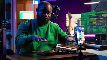 Music producer explaining faders and knobs on mixing console before teaching advanced post production stuff. Musical instructor gives advice about acoustical engineering, online vlog. Camera A. video