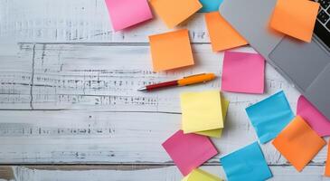 Colorful Sticky Notes and Laptop on Wooden Desk With Notepad photo