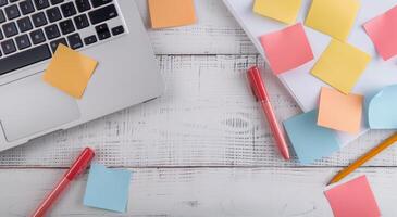 Colorful Sticky Notes and Laptop on Wooden Desk With Notepad photo