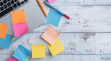 Colorful Sticky Notes and Laptop on Wooden Desk With Notepad photo