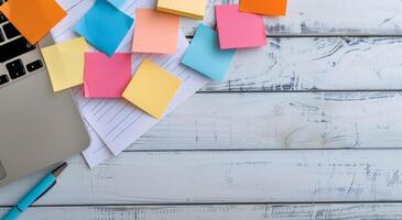 Colorful Sticky Notes and Laptop on Wooden Desk With Notepad photo