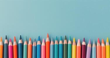 Colorful Collection of Pencils Arranged Neatly on a Light Blue Surface photo