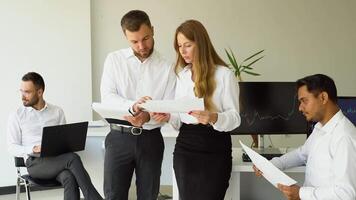 Smiling businesspeople having a discussion while collaborating on a new project in an office video