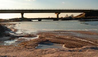 View of the old and new bridge over the canal on the banks of the Tiligul estuary, frozen water, Ukraine photo