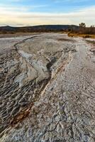Cracked red clay and white salt on the surface in a dried riverbed in the desert of New Mexico, USA photo