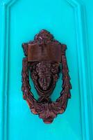 Traditional copper handle and door knocker on wooden doors of old houses in Malta, Gozo photo
