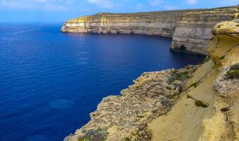 High vertical rocky shore on the island of Gozo, Malta photo