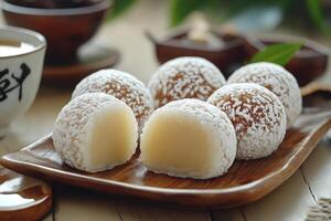 Powdered and Cut-Open Japanese Mochi Balls on a Wooden Plate photo