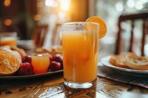 A Glass of Orange Juice with a Slice of Orange on a Table photo