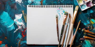 This inspiring mockup features a blank canvas surrounded by brushes and vibrant paints, ideal for creative projects and artistic expressions, perfect for artists wanting to ignite their imagination photo