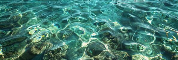 A serene underwater view beautifully showcasing clear blue waters along with rocky textures visible beneath the surface photo
