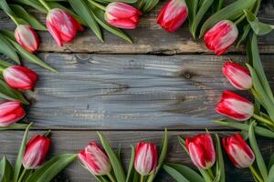 A stunning arrangement of vibrant red and pink tulips surrounds a rustic wooden surface, ideal for springthemed projects and celebrations during this joyous season of renewal and growth photo