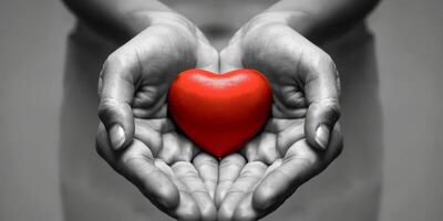 A vivid image of a red heart in warm hands, symbolizing love, compassion, and connection in communities photo