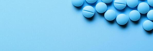 This visually appealing image features a neatly organized collection of vibrant blue pills on a soft blue surface, perfect for topics related to healthcare or the pharmaceutical industry photo