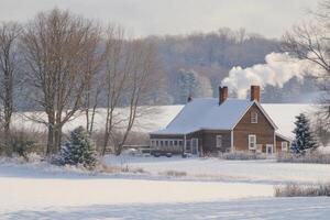 A farmhouse surrounded by snow in the countryside. photo