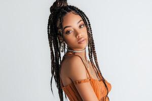 Full-body portrait of a young beautiful woman with boho braids, posing gracefully on a white studio background. photo