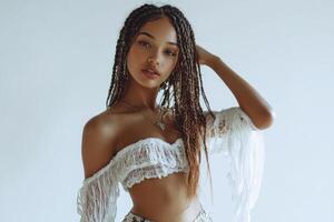 Full-body portrait of a young beautiful woman with boho braids, posing gracefully on a white studio background. photo