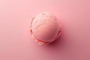 A top-down view of a pink ice cream scoop on a matching pink background. photo