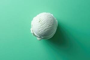 A top-down view of a mint green ice cream scoop on a mint green background. photo