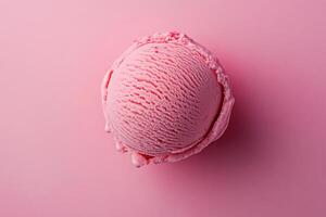 A top-down view of a pink ice cream scoop on a matching pink background. photo